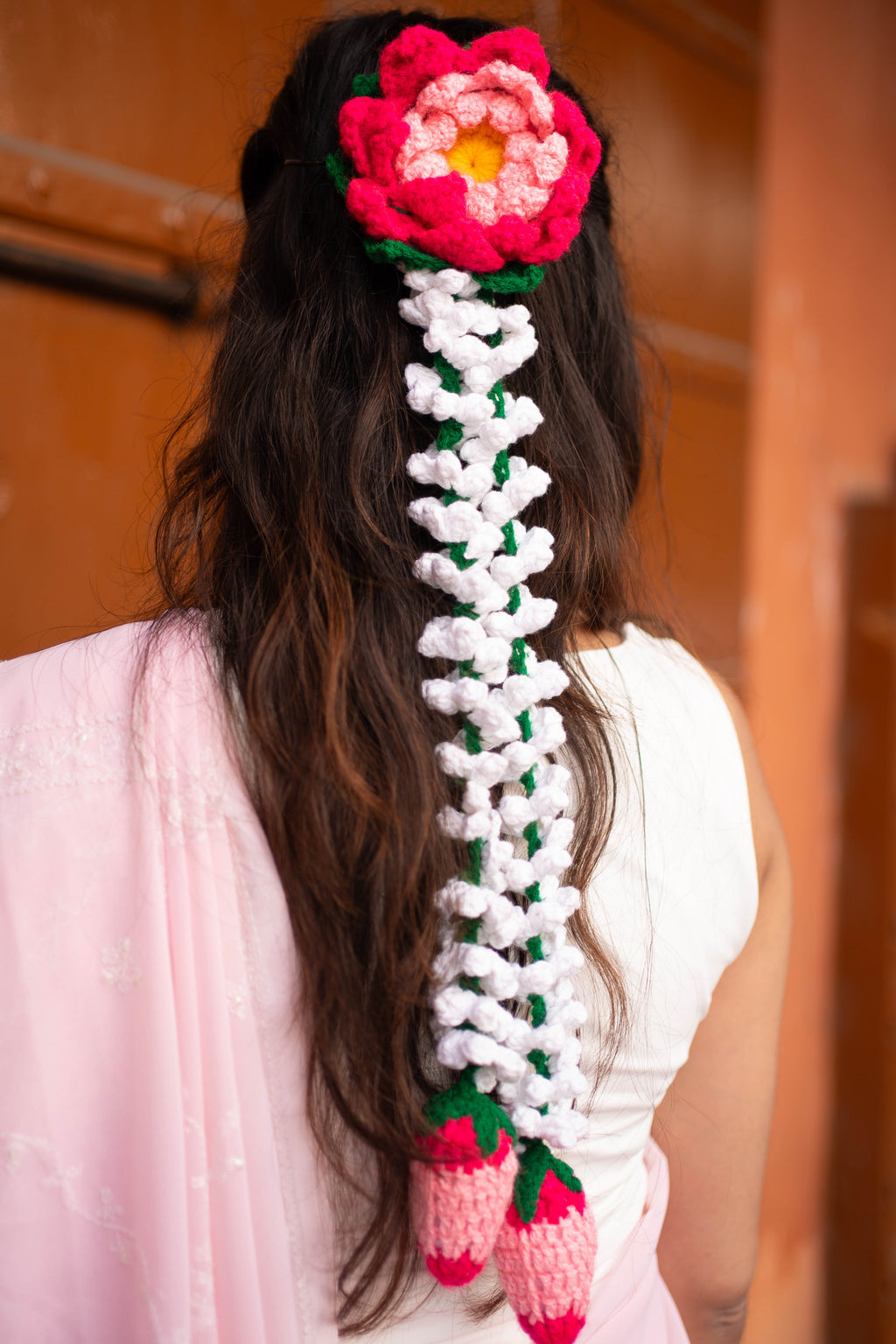 Person with a long, braided hairpiece decorated with Uun flowers